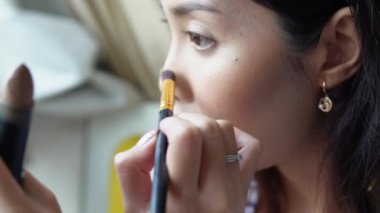 Makyaj fırçası ve puf kullanarak makyaj yapan güzel Asyalı bir kadının yakın plan portresi. Takılmaya hazırlanıyor. Güzellik ipuçları, güzellik vlogger konsepti