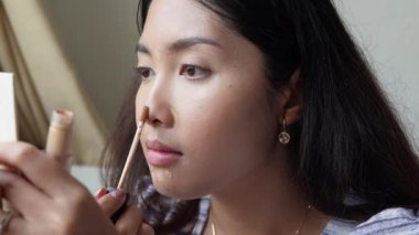 Makyaj fırçası ve puf kullanarak makyaj yapan güzel Asyalı bir kadının yakın plan portresi. Takılmaya hazırlanıyor. Güzellik ipuçları, güzellik vlogger konsepti