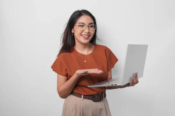 그녀가 보유하고있는 노트북을 제시하고 가리키는 셔츠를 즐거운 배경에 스톡 사진
