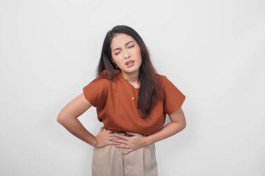 Hasta bir genç kadının portresi. Elini karnına koyuyor. Beyaz arka planda izole edilmiş acı çekiyor.