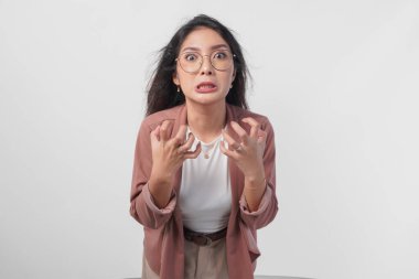 Gözlüklü sinirli Asyalı kadın, beyaz arka planda izole edilmiş kızgın, kızgın, hayal kırıklığına uğramış duygularını ifade ediyor..