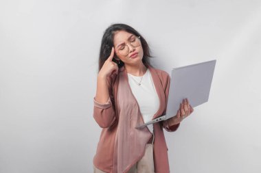 Gözlüklü düşünceli genç Asyalı iş kadını laptopuyla işi düşünüyor, beyaz arka planla izole edilmiş..