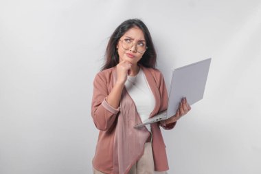 Gözlüklü düşünceli genç Asyalı iş kadını laptopuyla işi düşünüyor, beyaz arka planla izole edilmiş..