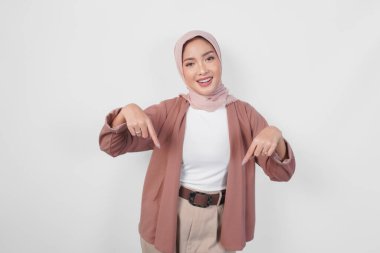 Tesettürlü, tesettürlü, tesettürlü, beyaz arkaplan tarafından izole edilmiş, fotokopi alanını gösteren bir kadın..