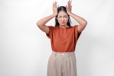 Şiddetli baş ağrısı çeken stresli Asyalı kadın, tapınaklara ellerini bastırıyor, acıyı dindirmek için gözlerini kapatıyor çaresiz yüz ifadesiyle..