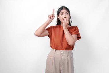 Kahverengi tişörtlü, korkmuş Asyalı kadın ağzını kapatırken fotokopi odasını yukarı çeviriyor. Şokta ya da güvensiz..