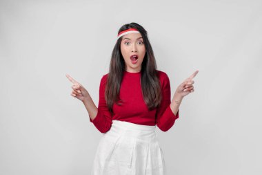 Kırmızı tişörtlü ve beyaz pantolonlu genç kadın yanındaki fotokopi odasını işaret ediyor, izole edilmiş beyaz arka plan. Endonezya Bağımsızlık Günü kavramı.