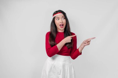 Kırmızı tişörtlü ve beyaz pantolonlu genç kadın yanındaki fotokopi odasını işaret ediyor, izole edilmiş beyaz arka plan. Endonezya Bağımsızlık Günü kavramı.