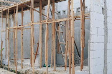 Duvara dayanmış bir merdiveni, bitmemiş bir evi ya da binası olan bir şantiye..