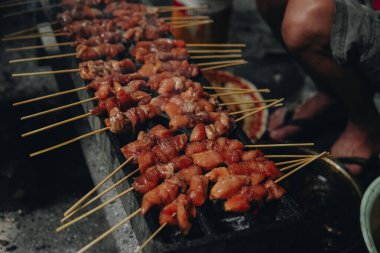 Endonezya tavuğunu geleneksel yöntemlerle pişirme süreci kömür, lezzetli Asya mutfağı.