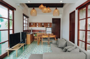 Oturma odası televizyon, mutfak ve yemek masası, ahşap mobilyalarla süslenmiş ve rahat bir atmosferi var..