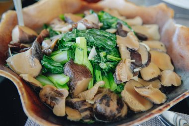 Lokanta menüsü olarak servis edilen bir kasede kızartılmış mantar ve bok choy..