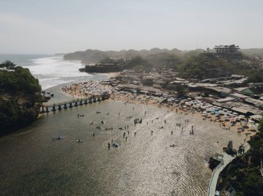 Gunungkidul, Yogyakarta, Endonezya 'daki Drini Sahili' nin havadan görünüşü. Beyaz kumlu plajlar, şemsiyeli, turistlerle dolu..