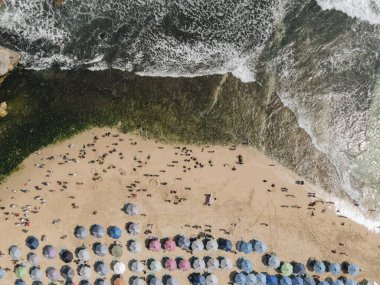 Gunungkidul, Yogyakarta, Endonezya 'daki Drini Sahili' nin en iyi manzarası. Bir sürü insan ve renkli sörf tahtaları var..