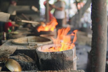 Lokantada geleneksel soba, üstünde kızgın kömür ve parlayan alevlerle yemek pişirmek için kullanılır..
