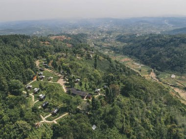 Dieng, Wonosobo, Endonezya 'da yemyeşil ormanlarla çevrili bir otel manzarası..