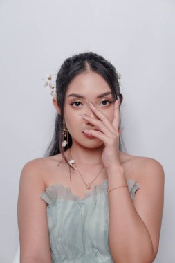 Elegant young Asian woman wearing luxurious dress and full make up posing against isolated white background. Beauty and make up concept.