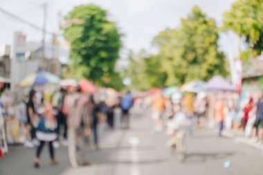 Kalabalık ve hareketli bir caddenin bulanık görüntüsü. Özgür bir günde yürüyen insanlar, açık havanın tadını çıkarıyor ve sosyalleşiyorlar..