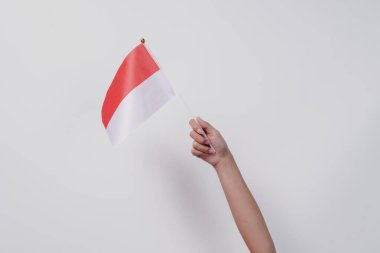 İzole edilmiş beyaz arka planda Endonezya kırmızı ve beyaz bayrağını tutan el ele. Endonezya 'nın bağımsızlık günü konsepti.