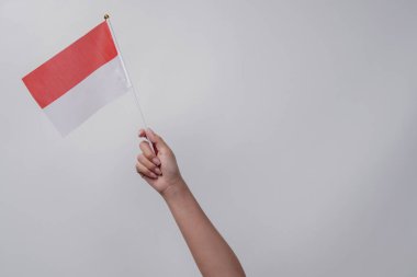 İzole edilmiş beyaz arka planda Endonezya kırmızı ve beyaz bayrağını tutan el ele. Endonezya 'nın bağımsızlık günü konsepti.
