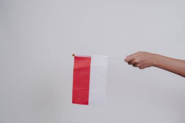 İzole edilmiş beyaz arka planda Endonezya kırmızı ve beyaz bayrağını tutan el ele. Endonezya 'nın bağımsızlık günü konsepti.