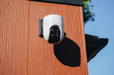 Güvenlik kamerası ahşap bir duvara ya da evin dışındaki çitlere monte edilmiş..