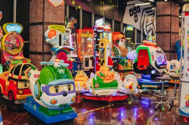 Bir atlıkarınca, bir helikopter ve bir tekne de dahil olmak üzere eğlence turları bir oyun merkezinde sıralanır..