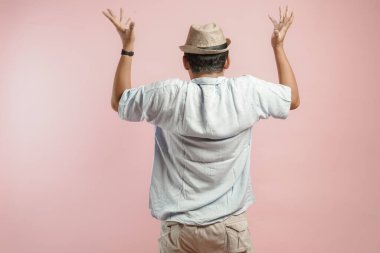 Şapkalı ve mavi gömlekli genç bir Asyalı 'nın arka portresi. Kafasını tutuyor. Stresli hissediyor..