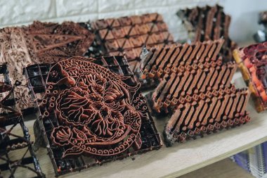 Endonezya 'da pul tekniği veya batik kapağı kullanılarak yapılan farklı renkte el yapımı el yapımı el işi batiklerle dolu rafı göster.