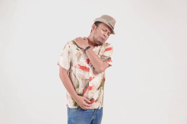 Acı çeken Asyalı yorgun genç bir adam. Omzunda ve boynunda beyaz arka planda izole edilmiş kas spazmı var..