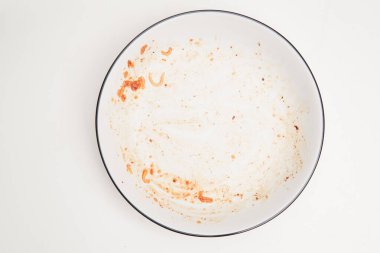 Öğle yemeğinden ya da akşam yemeğinden sonra beyaz arka planla izole edilmiş boş bir tabağın üst görüntüsü.