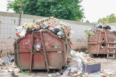 Son atık sahasında çöplerle dolu iki çöp konteynırı..