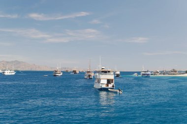 Beautiful seascape of Labuan Bajo filled with a collection of traditional boats Pinisi schooner sailing on the ocean.