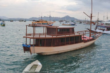 Beautiful seascape of Labuan Bajo filled with a collection of traditional boats Pinisi schooner sailing on the ocean.