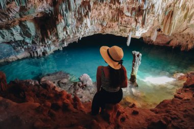 Back view of a young Asian woman enjoying holiday and scenery at Rangko Cave, Labuan Bajo, Indonesia.