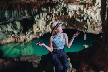 Joyful young Asian woman enjoying holiday and scenery at Rangko Cave, Labuan Bajo, Indonesia.
