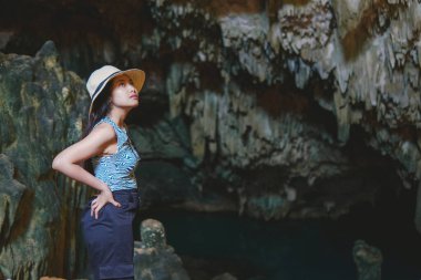 Chic young Asian woman enjoying holiday and scenery at Rangko Cave, Labuan Bajo, Indonesia.