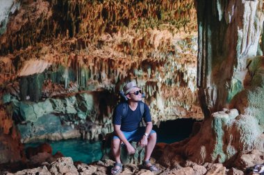 Joyful young Asian man enjoying holiday and scenery at Rangko Cave, Labuan Bajo, Indonesia.