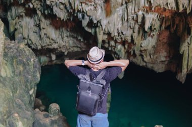 Excited young Asian man enjoying holiday and scenery at Rangko Cave, Labuan Bajo, Indonesia.