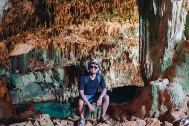 Joyful young Asian man enjoying holiday and scenery at Rangko Cave, Labuan Bajo, Indonesia.