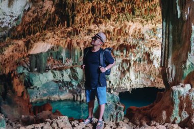 Smiling young Asian man enjoying holiday and scenery at Rangko Cave, Labuan Bajo, Indonesia.