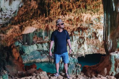 Smiling young Asian man enjoying holiday and scenery at Rangko Cave, Labuan Bajo, Indonesia.