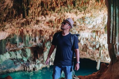 Smiling young Asian man enjoying holiday and scenery at Rangko Cave, Labuan Bajo, Indonesia.