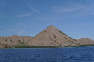 Labuan Bajo, Endonezya 'da arka planda mavi gökyüzü olan dağ manzarası.