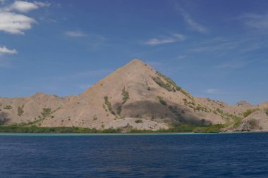 Labuan Bajo, Endonezya 'da arka planda mavi gökyüzü olan dağ manzarası.