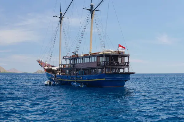 Labuan Bajo denizinde gün ışığında okyanusta yüzen Endonezya bayraklı büyük bir gemi..