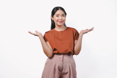 Kahverengi gömlekli ve kahverengi pantolonlu güzel Asyalı kadın beyaz arka planla izole edilmiş fotokopi odasını sunuyor..