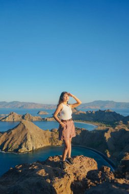 Happy young Asian woman is looking and enjoying scenery of Padar Island, Labuan Bajo, Indonesia.