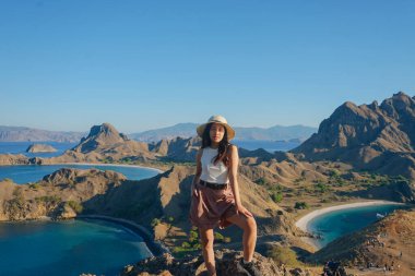 Gorgeous young Asian woman is posing for a picture at Padar Island, Labuan Bajo, Indonesia.