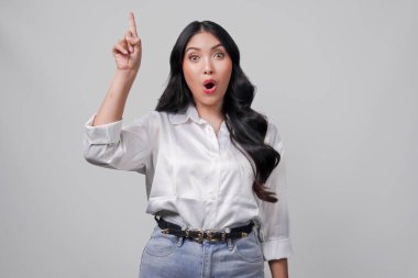 Beyaz tişörtlü genç Asyalı kadın beyaz arka planla izole edilmiş fotokopi odasını işaret ediyor..